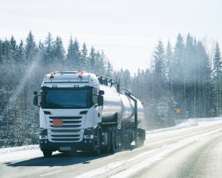 Un camion-citerne réalise une livraison malgré le froid, le gel et la neige